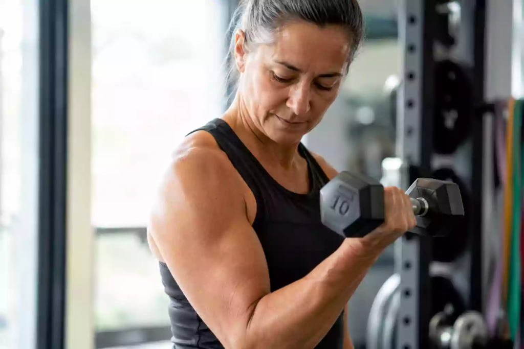 Middle-aged person performing strength training with a dumbbell to preserve muscle mass while taking GLP-1 weight loss medication.
